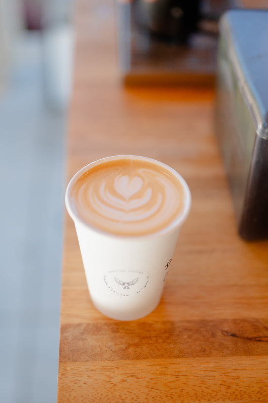A hot latte with milk art placed on a table, showcasing wedding coffee catering services in Georgia.