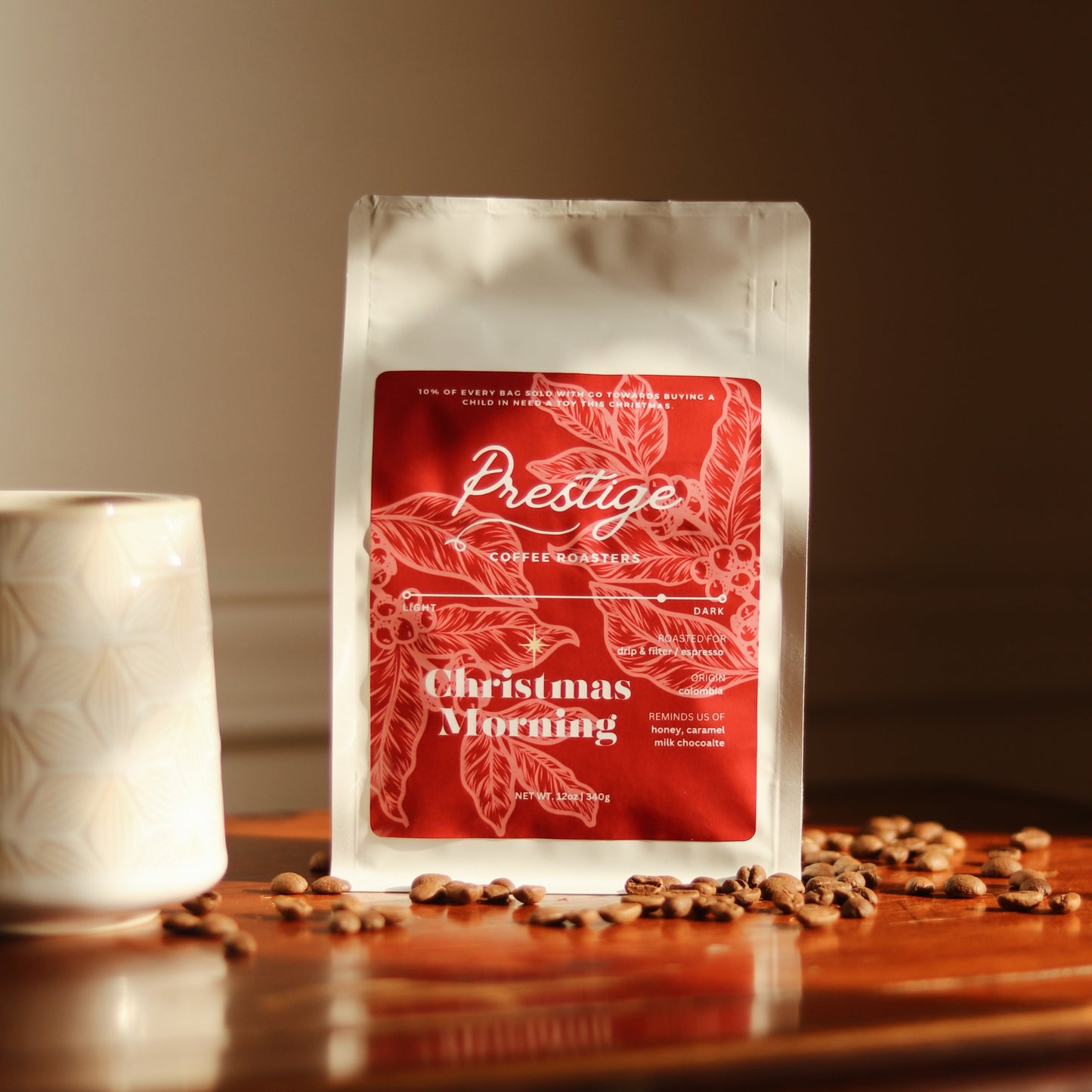 Coffee bag labeled 'Prestige' with a red design on a wooden surface.