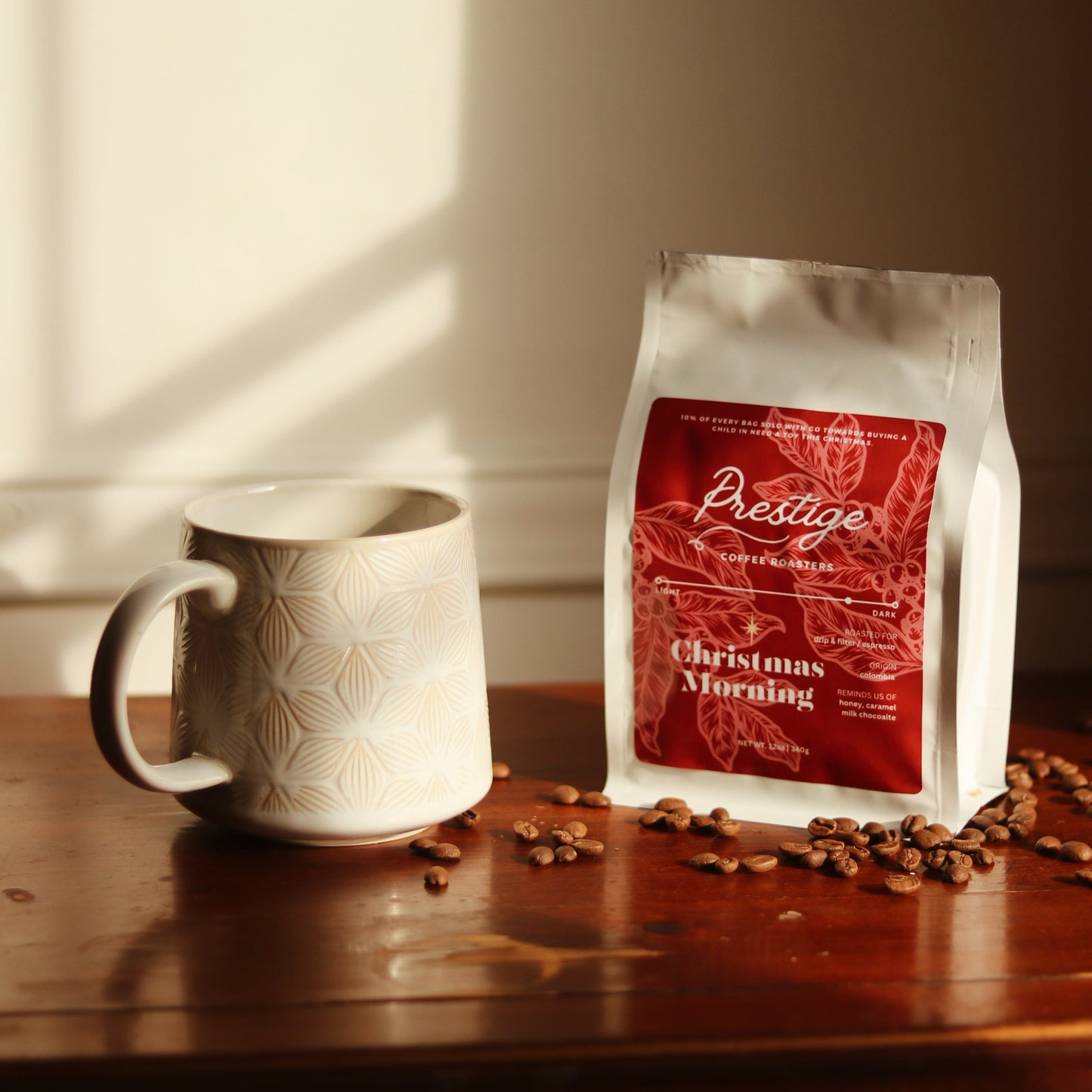 Prestige coffee bag with a mug and coffee beans on a wooden surface