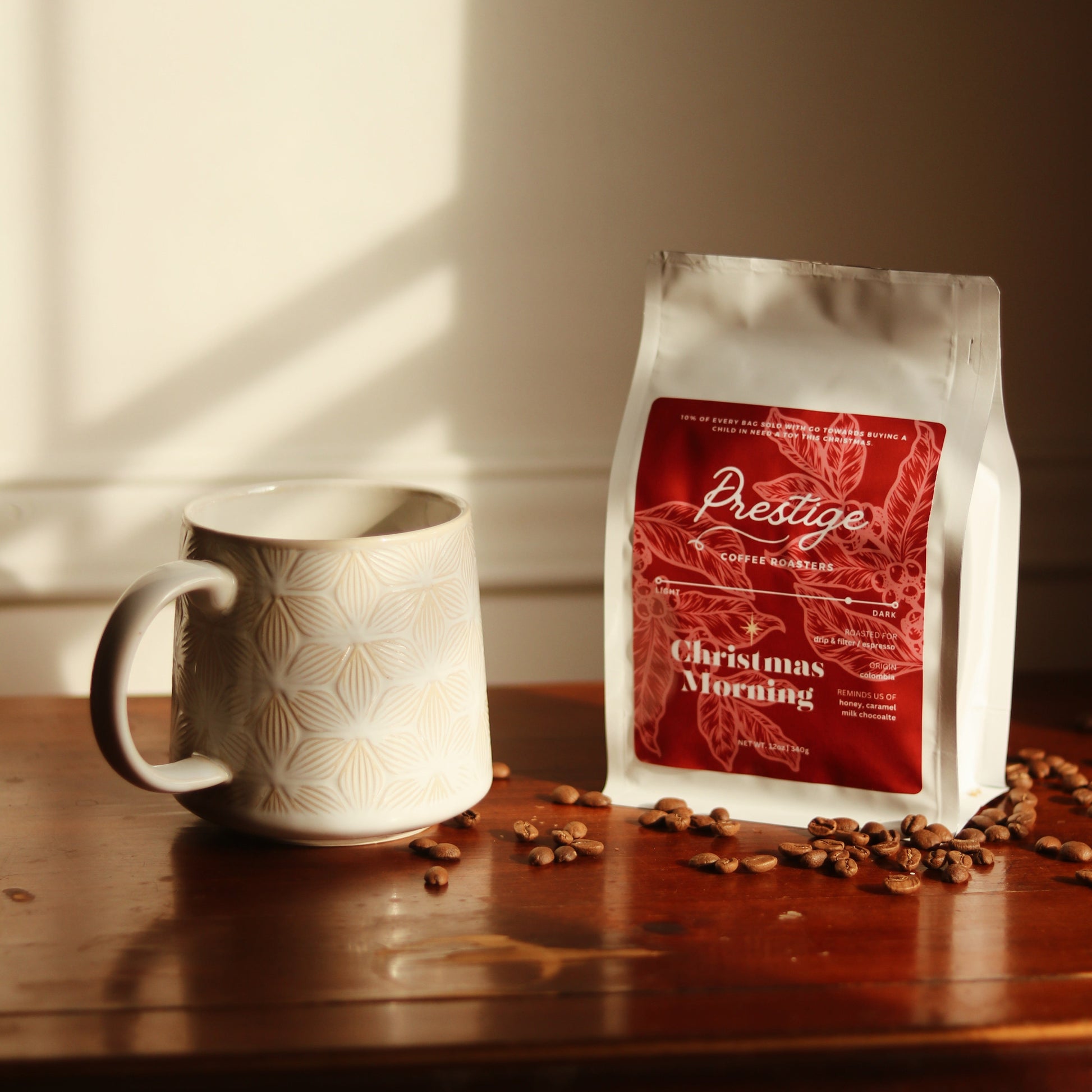 Prestige coffee bag with a mug and coffee beans on a wooden surface